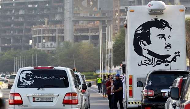 A painting depicting Qataru2019s Emir is seen on a bus during a demonstration in support of him in Doha
