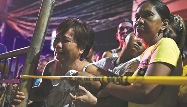 A relative of a victim cries behind the police line at the site of a drug-related shooting by unidentified men riding on motorcycles at Navotas City in Metro Manila.