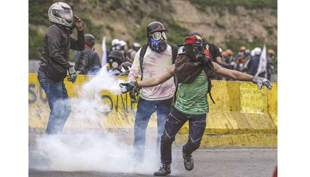 An opposition activist throws teargas back at riot police in clashes at the Francisco de Miranda air force base during a demonstration against the government of Venezuelan President Nicolas Maduro in Caracas on Saturday.