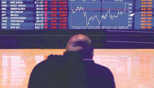 An investor sits in front of a board displaying stock prices at the Australian Securities Exchange in Sydney. The ASX  put on 0.1% yesterday.