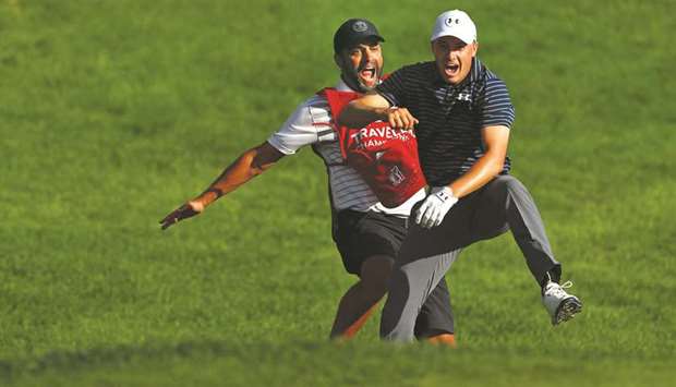 Jordan Spieth of the United States celebrates with caddie Michael Greller after chipping in for birdie from a bunker on the 18th green to win the Travelers Championship in a playoff against Daniel Berger of the United States (not pictured) at TPC River Highlands in Cromwell, Connecticut.