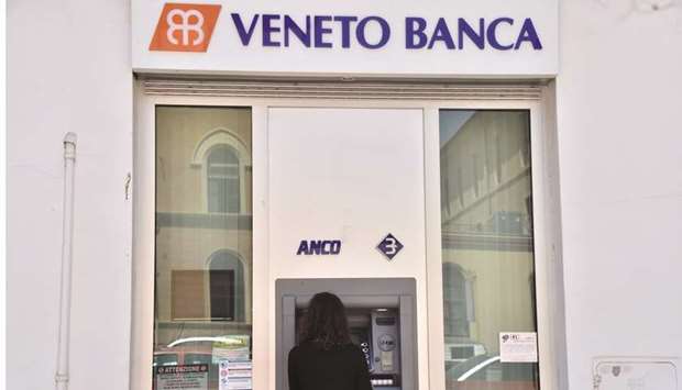 A woman uses an ATM at a branch of Italian bank Veneto Banca in Rome yesterday. Up to 3,900 voluntary redundancies and 600 branch closures are on the cards as the Italian government winds up two insolvent Venetian banks to avert a possible threat to the countryu2019s banking system.