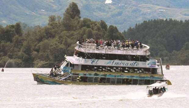 People crowd on to the upper deck and wait to be rescued as the Almirante begins to sink in the El Penol Reservoir in Guatape municipality in Antioquia.