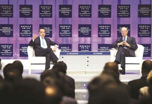 Chinese Premier Li Keqiang (left) and World Economic Forum founder and executive chairman Klaus Schwab attend the WEF in Dalian, Liaoning province. China is capable of achieving its full-year growth target and controlling systemic risks despite challenges, Li said yesterday, adding that maintaining medium to high-speed  long-term growth will not be easy.