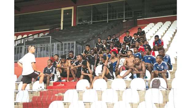 Trainer Johan Curbilie (left) talks to Katumbi Football Academy players at the Tout-Puissant Mazembe stadium in Lubumbashi, DR Congo. (AFP)