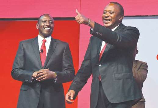Kenyau2019s President Uhuru Kenyatta, right, flanked by deputy president William Ruto, gestures during the unveiling of the Jubilee Partyu2019s manifesto in Nairobi.