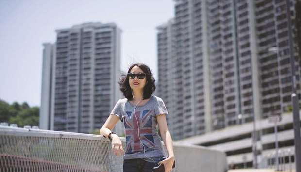 Dora, an administrator in a universityu2019s clinical department, poses while wearing a T-shirt with a British flag designed in Hong Kong.