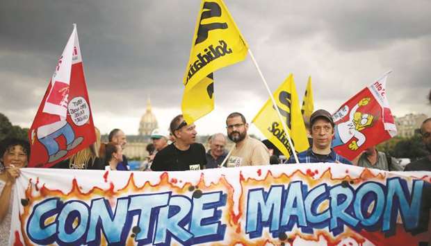 French unions gather to protest at the Invalides square in Paris yesterday. The placard reads u2018Against Macronu2019.