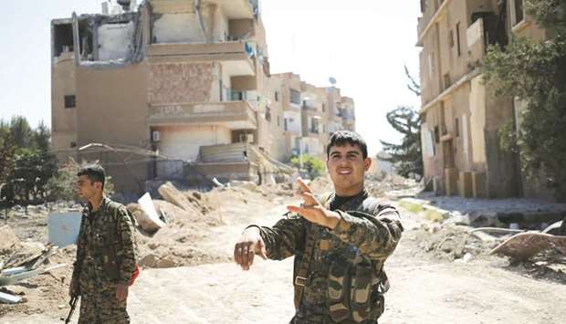 A Kurdish fighter from the Peopleu2019s Protection Units (YPG) gestures in Raqqa, yesterday.