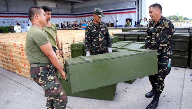 Philippine soldiers unload crates of firearms, provided through China's urgent military assistance