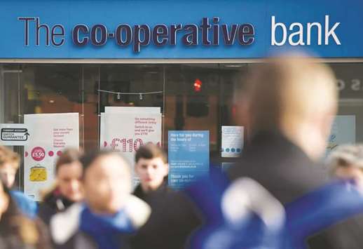 People walk past a branch of the Co-operative Bank in London. The bank has reached an agreement with investors on a u00a3700mn recapitalisation plan, enabling the UK lender to avoid being broken-up by regulators.
