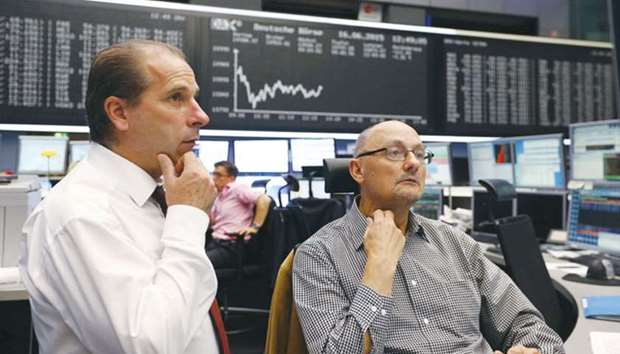 Traders work at the Frankfurt Stock Exchange. The DAX 30 closed down 0.2% to 12,647.27 points yesterday.