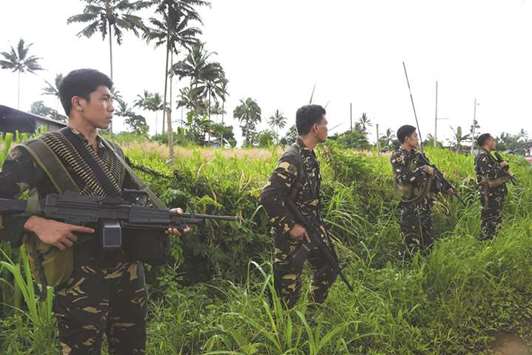 Philippine soldiers secure a road as they provide security for a retrieval operation of dead civilians in the outskirts of Marawi on the southern island of Mindanao.