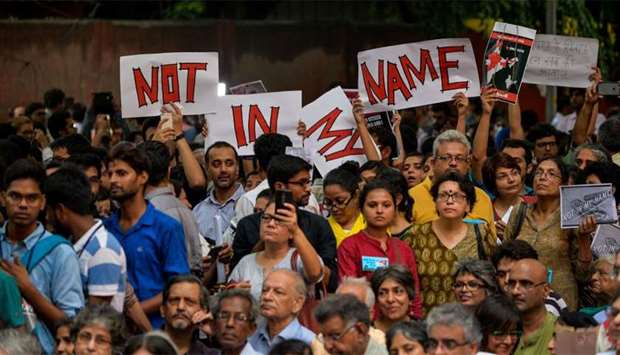 Indian protesters holding placards as they gather during a 'Not in my name' silent protest at Jantar