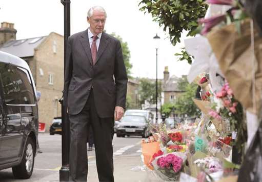 Retired Court of Appeal judge Sir Martin Moore-Bick, who will lead the Grenfell Tower fire public inquiry, looks at flowers left in tribute to the victims as he leaves St Clementu2019s Church near the Grenfell Tower block in west London yesterday.