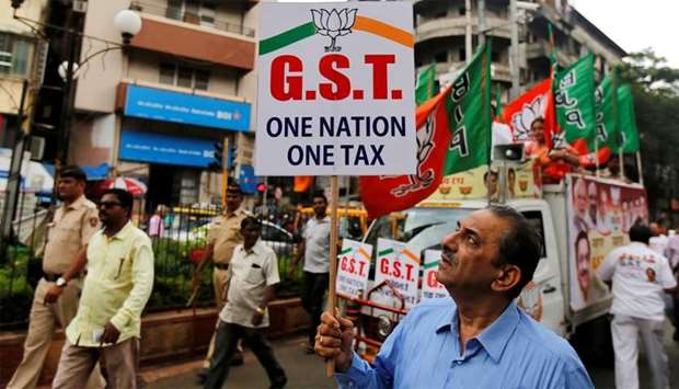 A supporter holds a placard  to support implementation of GST in Mumbai