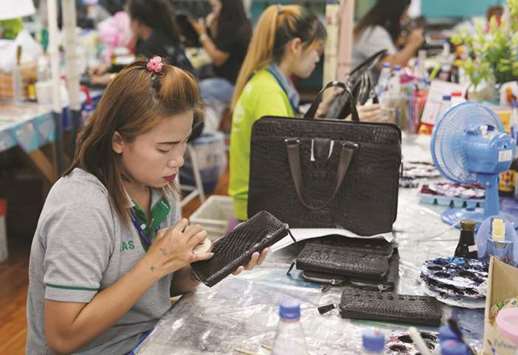 A worker polishes a wallet made from crocodile skin at Sri  Ayuthaya Crocodile farm in Ayutthaya province, Thailand.
