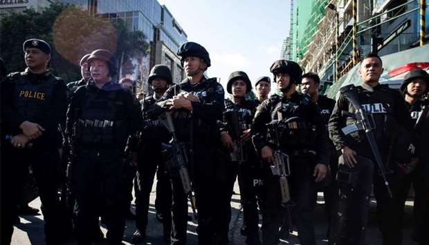 Philippines' police officers stand in front of the Resorts World Hotel following an assault in Manila