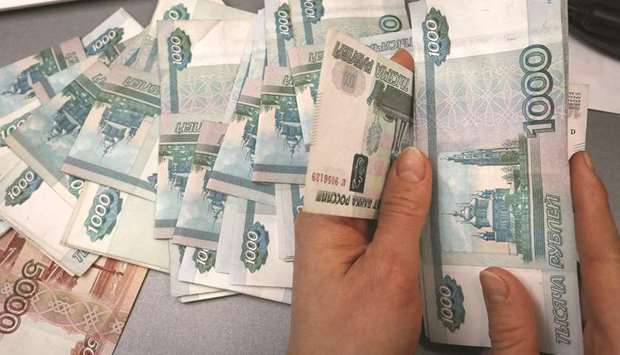 An employee counts rouble banknotes at a shop in Krasnoyarsk, Russia. The roubleu2019s link with oil is proving resilient. Its 30-day correlation with the price of Brent is now near 0.6, compared with 0.2 on February 7, when the purchases began.