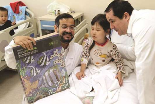 Doctors pose with a young heart patient in a Kazakh hospital.