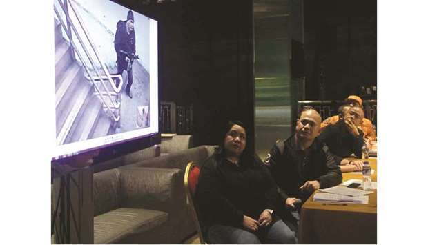 Police and Bureau of Fire officials, and Resorts World representatives watch surveillance video footage showing the gunman who on June 2 stormed into the casino and hotel complex, during a press conference in Manila yesterday.