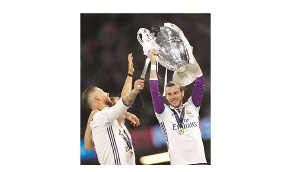 Real Madrid captain Sergio Ramos and Real Madridu2019s Welsh striker Gareth Bale (right) pose for a selfie with the trophy after Real Madrid won the UEFA Champions League final football match between Juventus and Real Madrid.