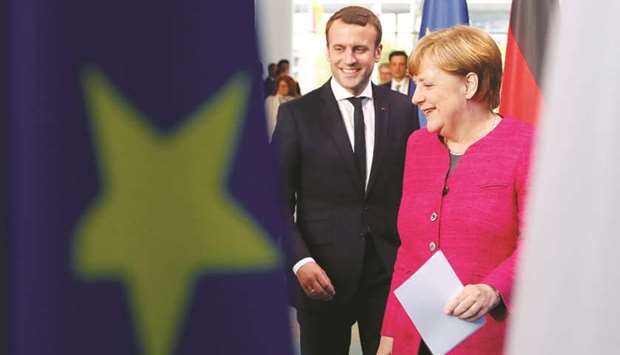 Merkel and Macron arriving to a news conference at the Chancellery in Berlin.