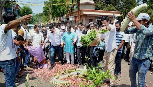 People throwing vegetables on a road during their nation-wide strike and agitation over various demands in Bhopal, Madhya Pradesh, on Sunday.  Picture courtesy: PTI
