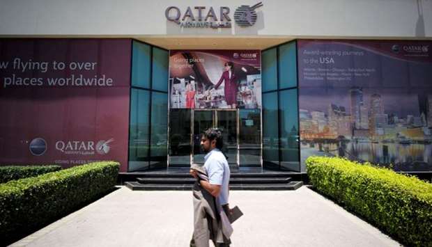 A man walks past Qatar Airways office in Manama, Bahrain.