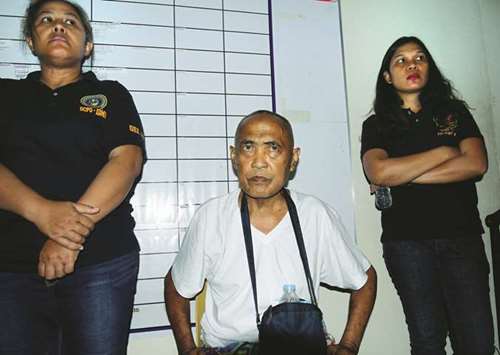 Cayamora Maute, a man who said he was the father of two brothers whose Maute group of militants led the seizure of  Marawi city two weeks ago, is guarded by police women after his arrest in Davao city, southern Philippines yesterday.