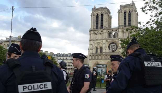 French police officials gather near the site of an attack at the entrance of Notre-Dame cathedral