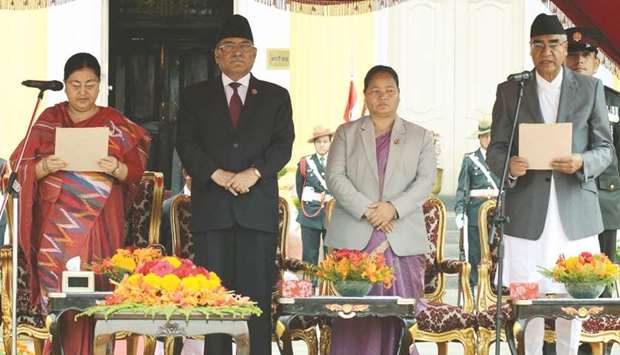 Sher Bahadur Deuba, right, is sworn in by Nepalese President Bidhya Bhandari, left, as outgoing prime minister Pushpa Kamal Dahal (second left) and parliament speaker Onsari Gharti Magar (second right) look on at the Presidentu2019s House in Kathmandu yesterday.