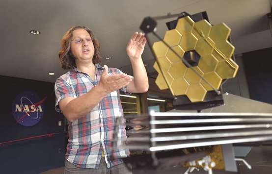 HOLDING FORT: Joel Green, an astrophysicist, talks about how the James Webb Space Telescope works as he stands next to a model of it in Baltimore in April at the James Webb Space Telescope flight control room at the Space Telescope Science Institute. It is where scientists will launch commands to the telescope once it reaches space in late 2018 and early 2019. The telescope is the successor to the Hubble Space Telescope and is expected to give new views of and insights into the early universe.