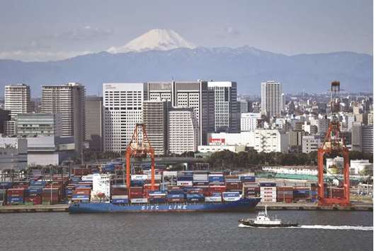 A freighter being anchored at the international container pier at Tokyo port, as Japanu2019s landmark Mt Fuji is seen in the background. Japanu2019s economy grew less than initially thought in the first quarter, revised government data showed yesterday.