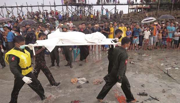 Soldiers carry dead bodies from a crashed military plane outside Launglon township, Myanmar, yesterday.