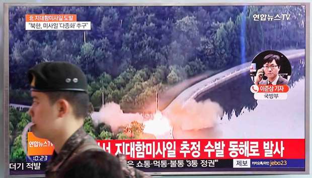 A South Korean soldier walks past a TV broadcast of a news report on North Korea firing what appeared to be several land-to-ship missiles off its east coast, at a railway station in Seoul, South Korea.