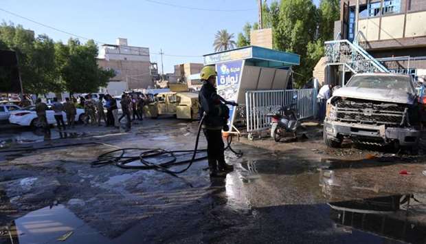 A firefighter hoses down a street after a suicide bomb attack in the city of Kerbala
