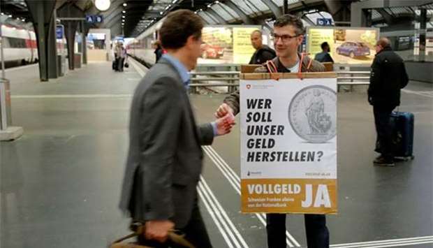 A member of the Sovereign Money Initiative offers flyers to travellers at the central railway station in Zurich last month.