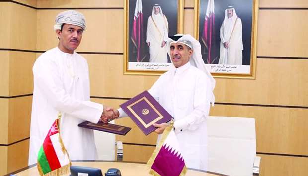 Dr Ibrahim bin Saleh al-Nuaimi and Najeeb bin Yahya Al Balushi exchanging the documents after signing an MoU in Doha.