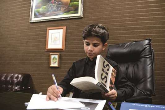 NOTEWORTHY: The 11-year-old motivational coach Hammad Safi takes notes at a languages academy in Peshawar. AFP photos