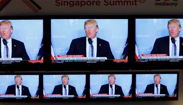 A TV news reports about US President Donald Trump is projected on TV sets at a media center for the summit between the U.S and North Korea in Singapore