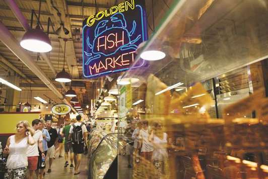 People walk past the fish market at the Reading Terminal Market in Philadelphia. The US consumer price index rose 0.2% from the previous month and 2.8% from a year earlier, matching estimates, a Labor Department report showed yesterday. The annual gain was the biggest since February 2012 and follows a 2.5% increase in April.