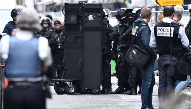 Police officers of the BRI intervention squad prepare a shield near the site of the hostage taking in central Paris.