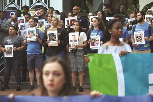 People hold pictures of victims of the Pulse nightclub shooting during a rally in front of Orlando City Hall on Monday.