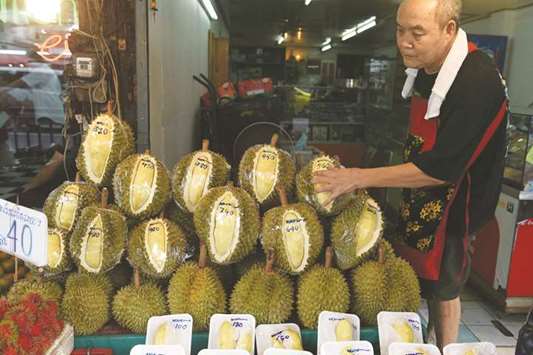 A Thai fruit vendor arranges a display of durians at his shop in Bangkok yesterday.
