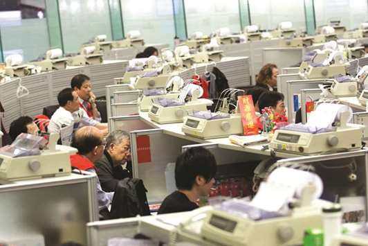 Traders work at the Hong Kong Stock Exchange (file). The Hang Seng closed down 1.2% to 30,725.15 points yesterday.