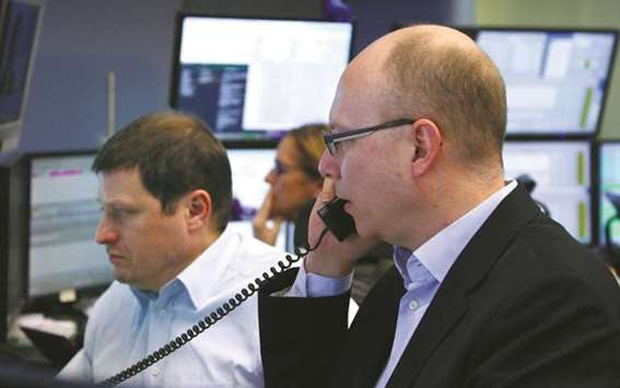 Traders look at their screens at the Frankfurt Stock Exchange. The DAX 30 index was 0.4% higher at 12,890.58 points at the close yesterday.