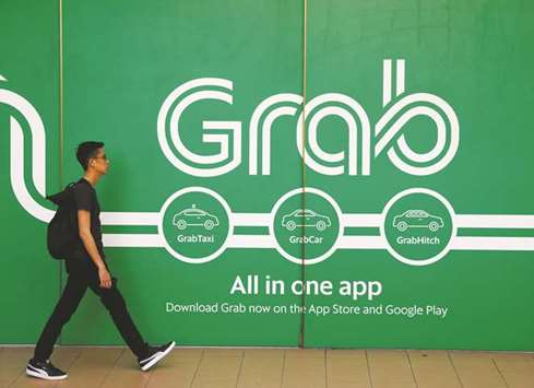 A man walks past a Grab office in Singapore. Toyota Motor and Grab are exchanging information on autonomous driving, but no decision has been made on collaboration in that area, a Toyota spokeswoman said.