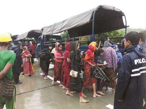 This handout picture released by Myanmar News Agency yesterday shows a group of Muslim women composed of Rohingya and Bangladeshis boarding police trucks in Rathedaung township in Rakhine state.