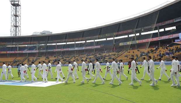 Afghan and Indian cricketers walk onto the ground before the start of the one-off cricket Test match between India and Afghanistan